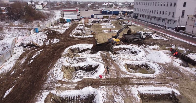 Aerial top view: yellow excavator pouring soil into tipper. Preparing place to construction residential house. top down stock photos