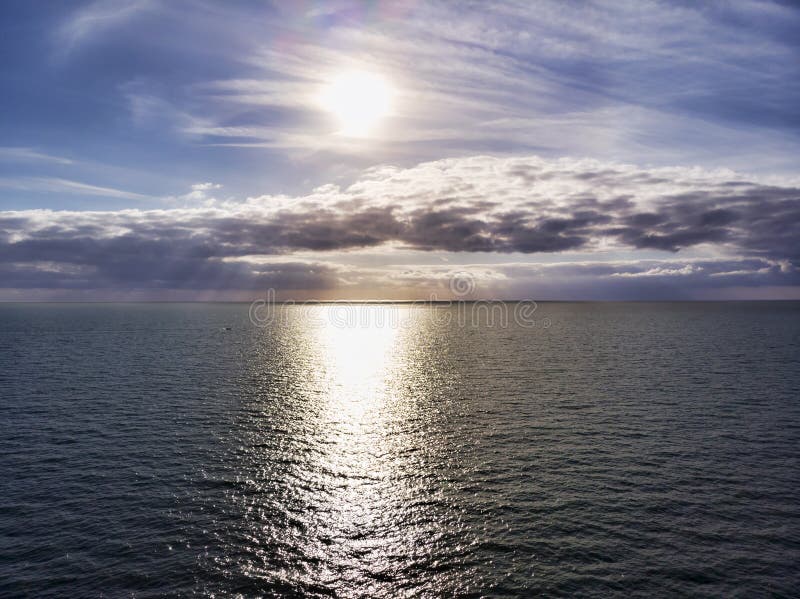 Aerial view above ocean, with cloudy pastel colored scenic sky and sun rays hits the water in a hot summer day royalty free stock photos Aerial view above ocean, with cloudy pastel colored scenic sky and sun rays hits the water in a hot summer day royalty free stock photos
