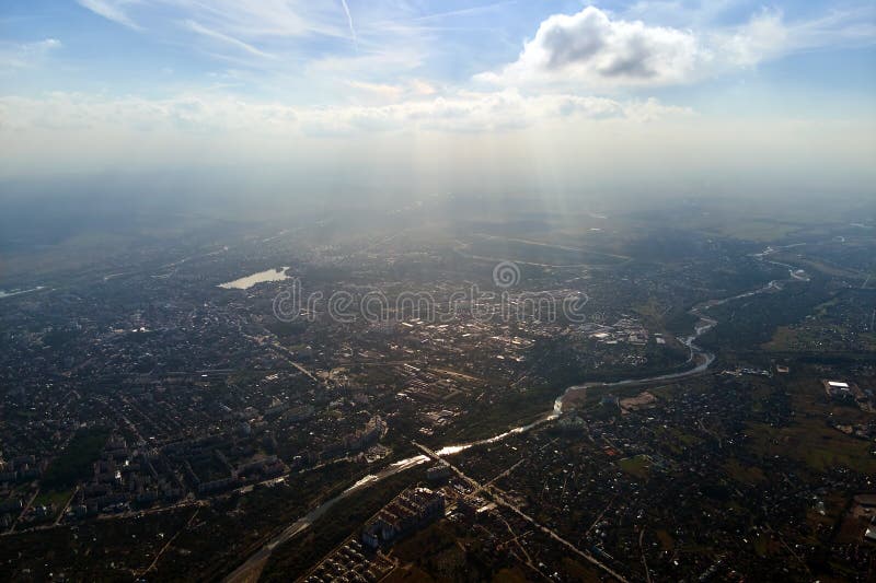 Aerial view from airplane window at high altitude of earth covered with white thin layer of misty haze and distant