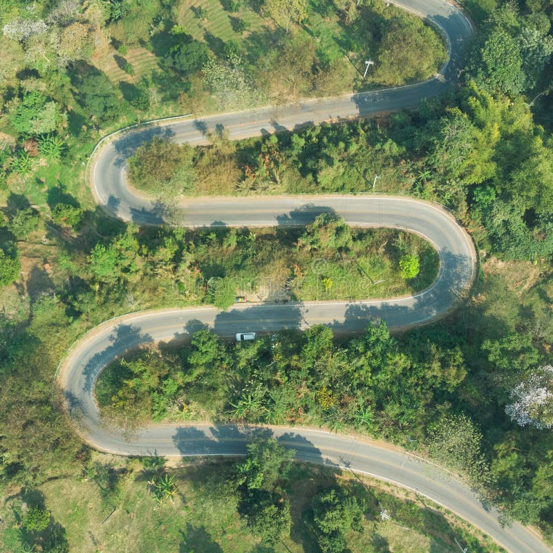 Aerial view of asphalt winding road in the forest mountain for background.Scenic view of Sharp curve road by drone safty drive and