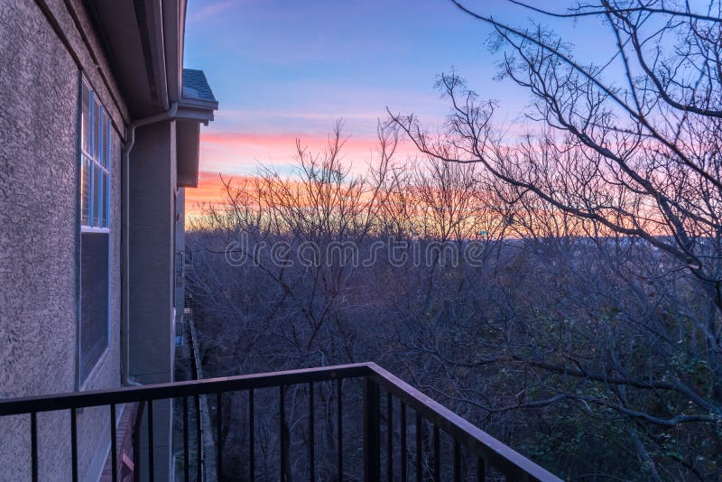 Park Side Apartment Complex Balcony during Winter Sunrise with Dramatic Clouds Stock Image