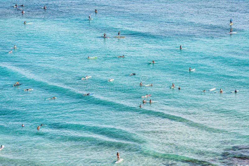 Aerial view of beach travel vacation Hawaii holiday with surfers people swimming in blue ocean water surfing on waves with