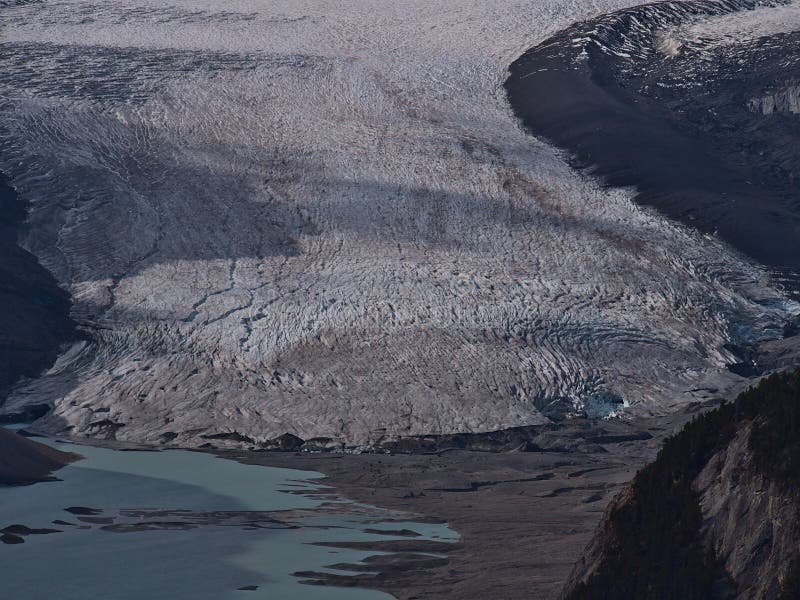 Aerial view of the break-off edge of majestic Saskatchewan Glacier with glacial lake, morain and crevasses in Canada.