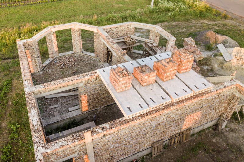 Aerial view of building site for future house, brick basement floor and stacks of brick for construction royalty free stock photo