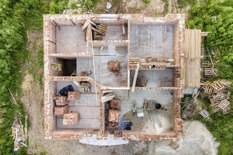 Aerial view of building site for future house, brick basement floor and stacks of brick for construction royalty free stock image