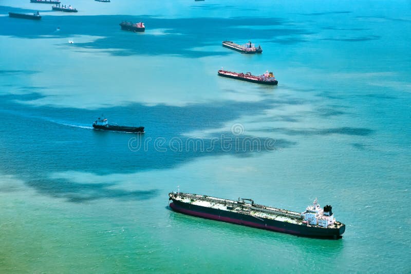 Aerial view of container ships in Singapore Strait. Airplane shot. Cargo ships anchored in the road, waiting to enter