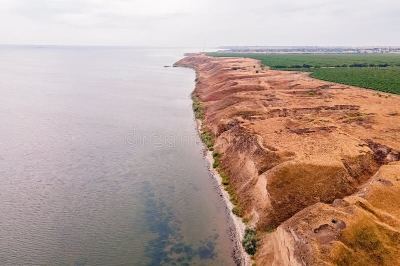 Aerial view of clay hills with canyons near the sea.