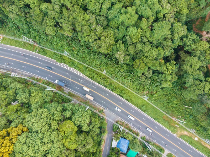 Aerial view curve road on mountain with tropical forest and car transport