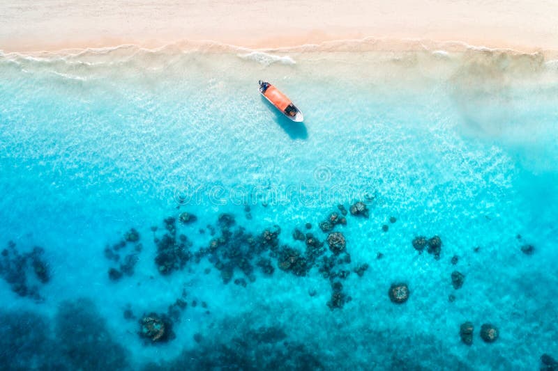 Aerial view of the fishing boats in clear blue water at sunset