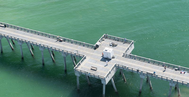 An aerial view of a fishing pier in Panama City Beach,Florida in the waters of the emerald green Gulf of Mexico