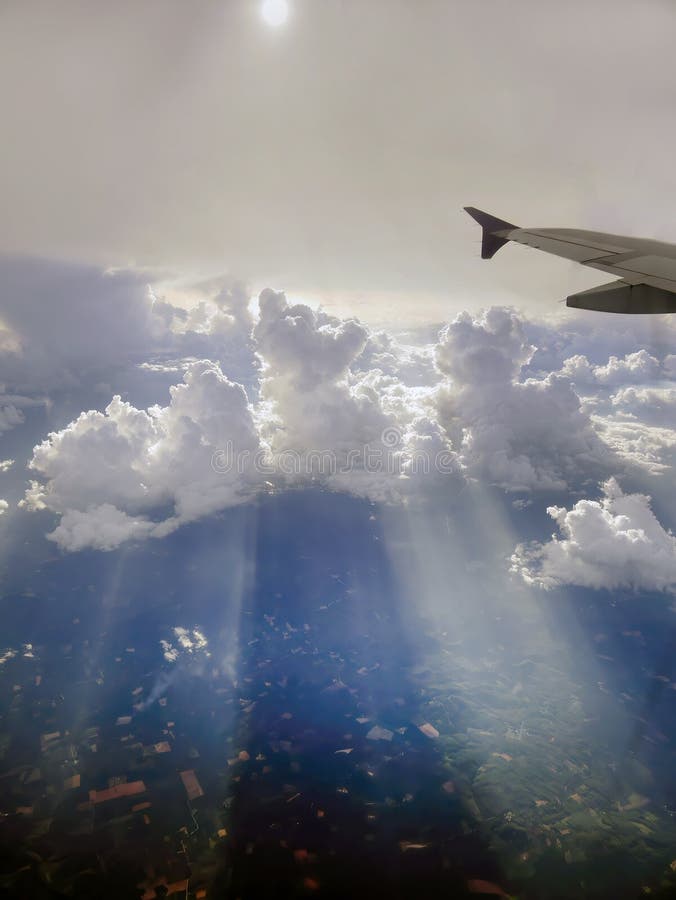 Aerial view flying above dramatic fluffy clouds and sun rays piercing shining through the clouds, cloudscape, sunlight, part royalty free stock photos