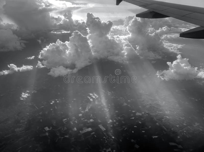 Aerial view flying above dramatic fluffy clouds and sun rays piercing shining through the clouds, cloudscape, sunlight royalty free stock photography
