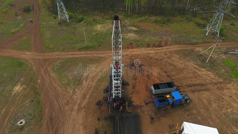 Company Employees Work on Oil Rig against Forest