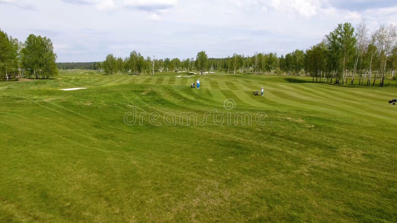 Aerial view Golf course. Golfers walking down the fairway on a course with golf bag and trolley stock images Aerial view Golf course. Golfers walking down the fairway on a course with golf bag and trolley stock images