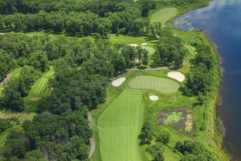 Aerial view of a golf course hole with sand traps alongside a lake on a summer day royalty free stock image