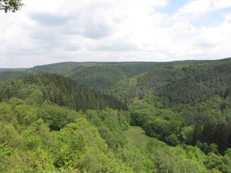 Aerial view at the green hills with pines and deciduous trees in the belgian ardennes in springtime. Aerial view at the green hills with pines and deciduous trees in the belgian ardennes in springtime