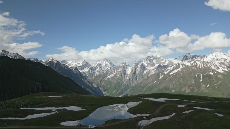 Aerial view of hiker with backpack at Koruldi lakes surrounded by Svaneti mountains. Scenic drone of person exploring stock video footage