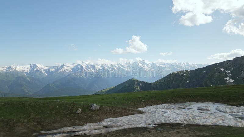 Aerial view of hiker backpack walking by Koruldi lakes, Svaneti mountains. Snow-capped peaks, clear lake reflections stock video