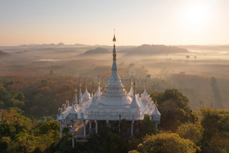 Aerial view of Khao Na Nai pagoda stupa. Luang Dharma Temple Park with green mountain hills and forest trees, Surat Thani