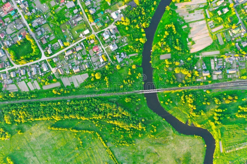 Aerial view landscape of winding small river among the small town, stream in green field, top view meadow