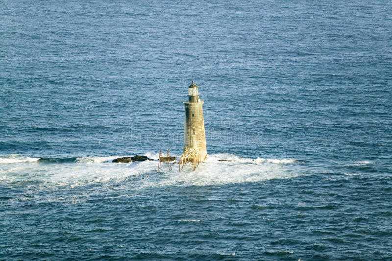 Aerial view of lighthouse at sea surrounded by water on Maine coastline, south of Portland