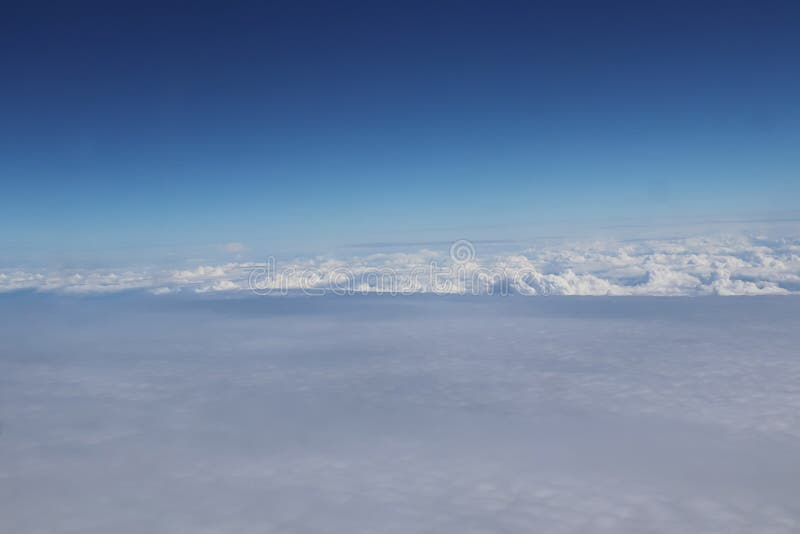 Aerial view of massive clouds and beautiful summer blue sky from aircraft window. Image use for environment and meteorology stock image