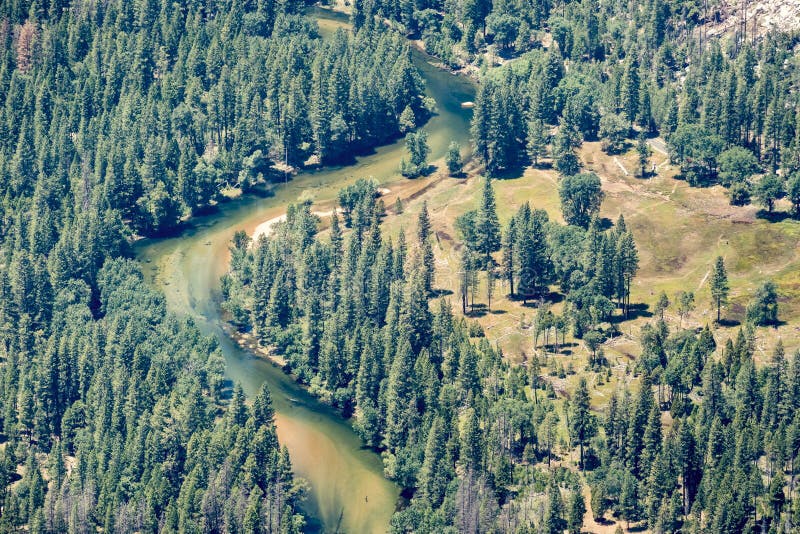 Aerial View Of Merced River Flowing Through Evergreen Forests In