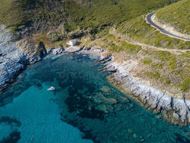 Aerial view of a moored boat floating on a transparent sea. Small house on the rocky coast of Cap Corse. Corsica. France stock photography Aerial view of a moored boat floating on a transparent sea. Small house on the rocky coast of Cap Corse. Corsica. France stock photography