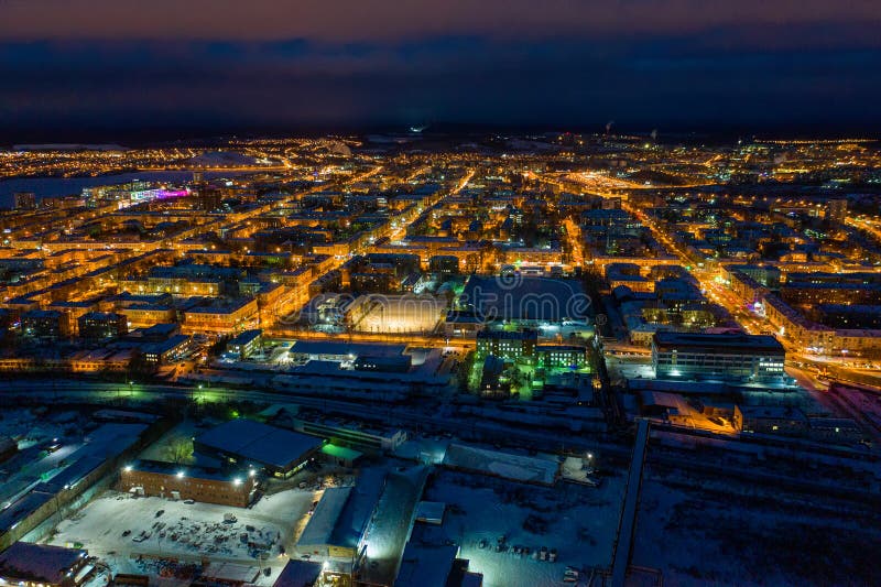 Aerial view of night city in winter. Movement of cars on lighted streets and intersections