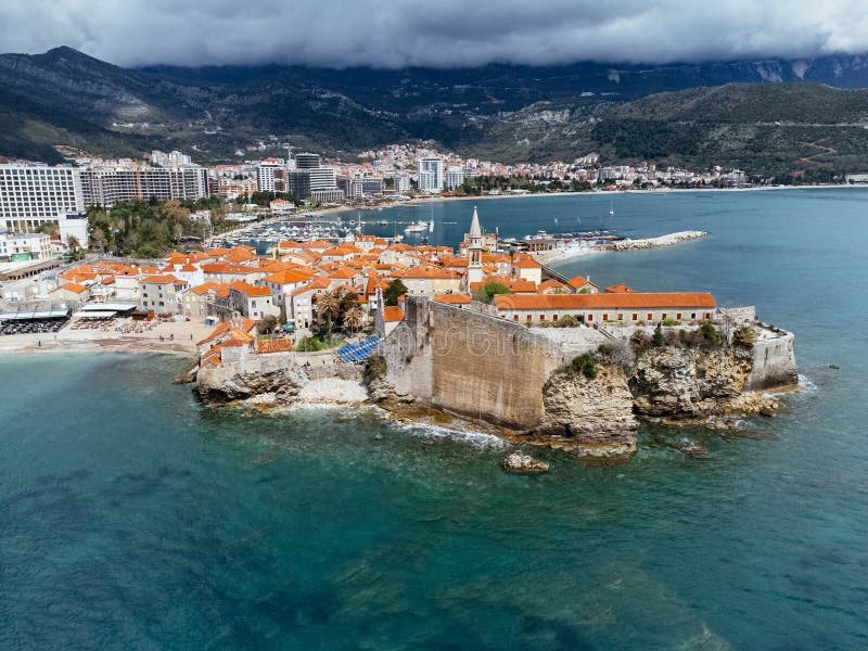 Aerial view of the Old Budva town, port, beach, and mountains. royalty free stock photo
