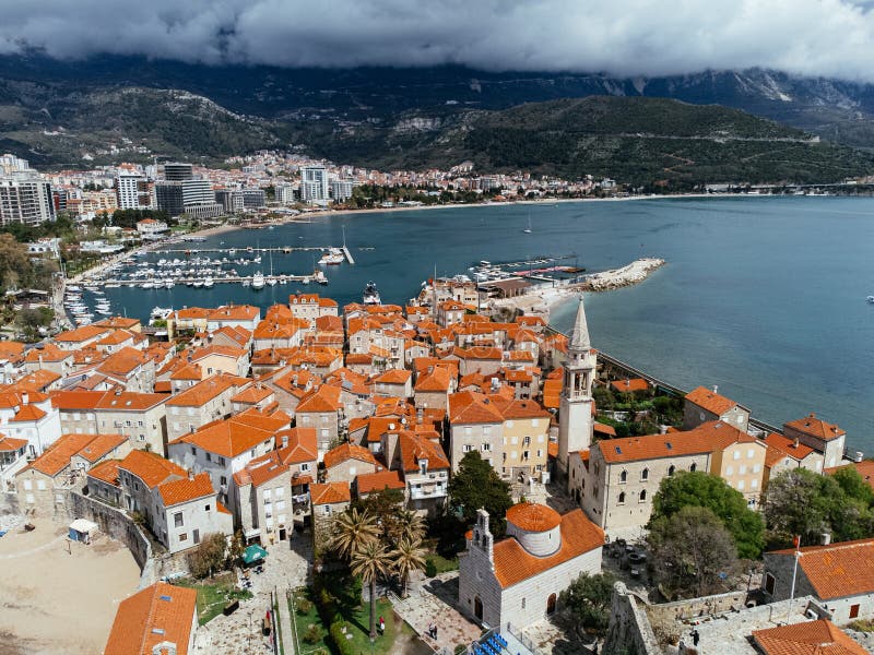 Aerial view of the Old Budva town, port, beach, and mountains. royalty free stock photography
