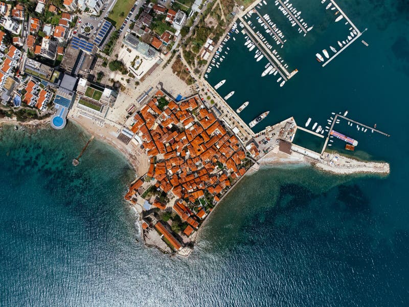 Aerial view of the Old Budva town, port, beach, and mountains. royalty free stock images