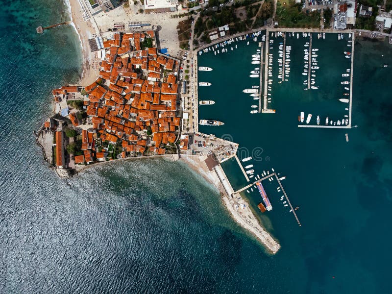 Aerial view of the Old Budva town, port, beach, and mountains. stock images
