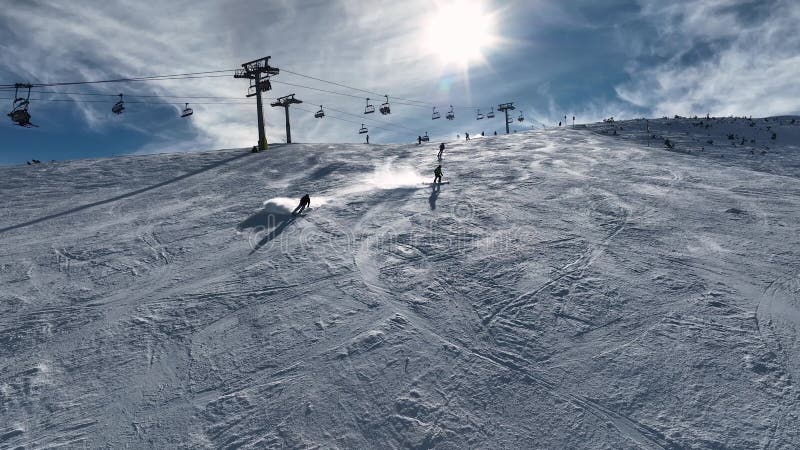 Aerial view over snowy mountain winter forest with chair lift at ski resort. stock footage