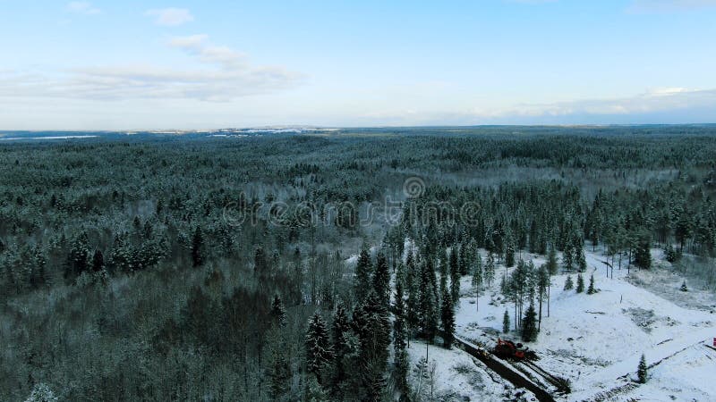 Aerial view over winter forest with two lonely houses surrounded by snowy trees on blue cloudy sky background. Motion royalty free stock photos Aerial view over winter forest with two lonely houses surrounded by snowy trees on blue cloudy sky background. Motion royalty free stock photos