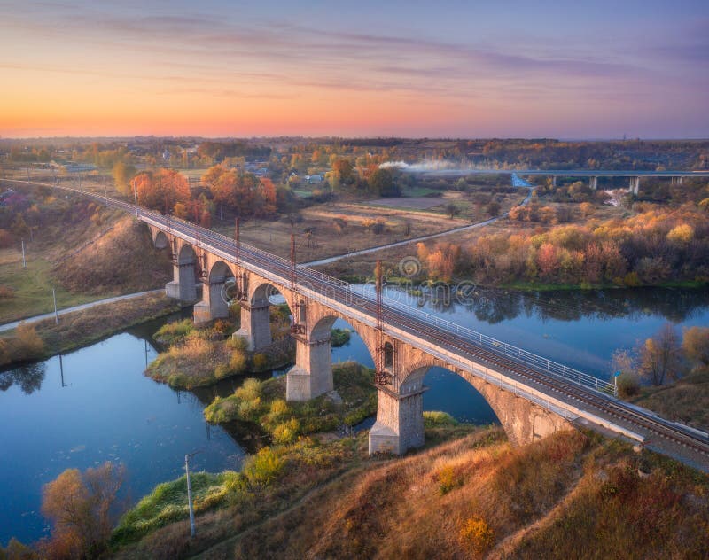Vista aerea da linee ferroviarie ponte un un fiume sul bellissimo tramonto autunno.