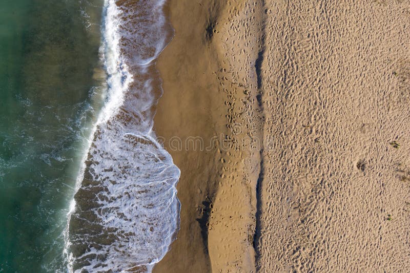 Aerial view of a remote sandy beach and sea waves stock images