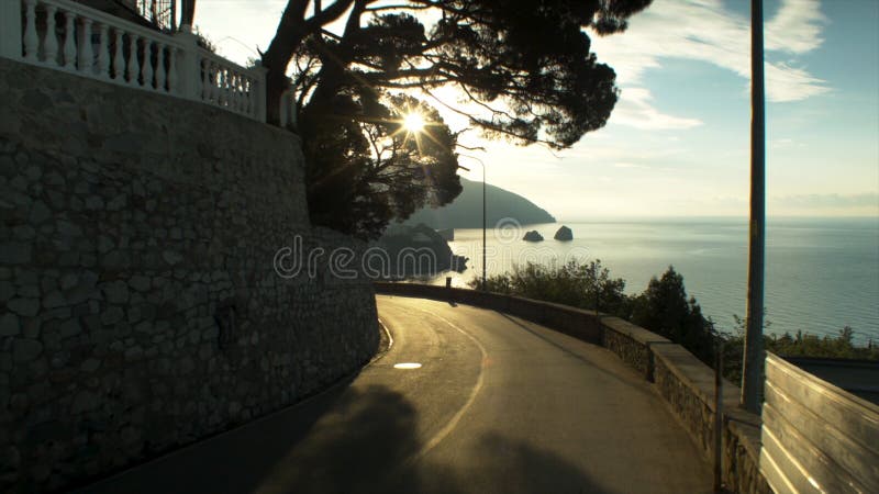 Aerial view on road by the sea and dramatic sky with sunset, lonely rock background. Shot. Sunset over the Highway in royalty free stock photography Aerial view on road by the sea and dramatic sky with sunset, lonely rock background. Shot. Sunset over the Highway in royalty free stock photography