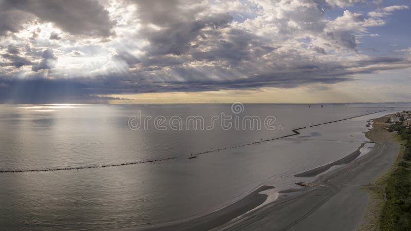 Aerial view of sandy beach and stormy sky with sun rays piercing the clouds stock image