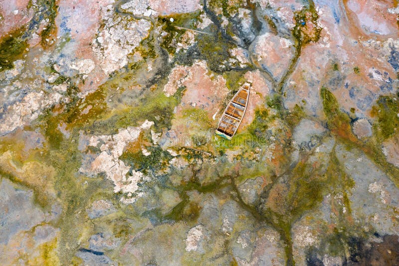 Aerial view of the small boats for salt collecting at pink Lake Retba or Lac Rose in Senegal. Photo made by drone from above.