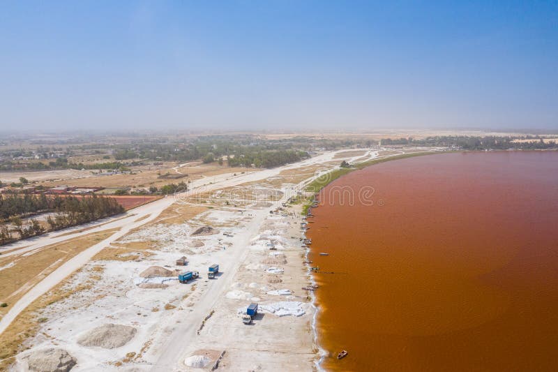 Aerial view of the small boats for salt collecting at pink Lake Retba or Lac Rose in Senegal. Photo made by drone from above.