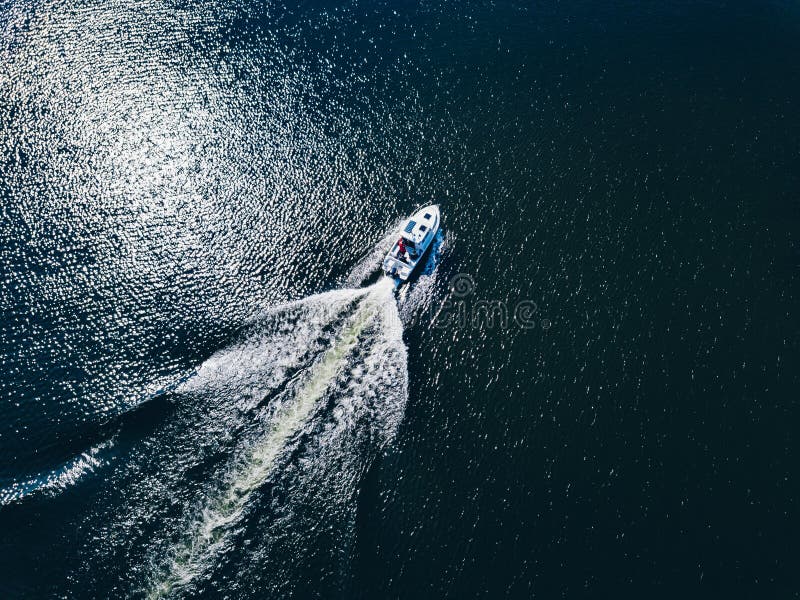 Aerial view of speed Boat or yacht at blue sea or lake leaving a wake