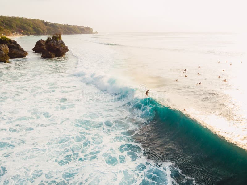 Aerial view with surfers and barrel wave in ocean, Padang Padang