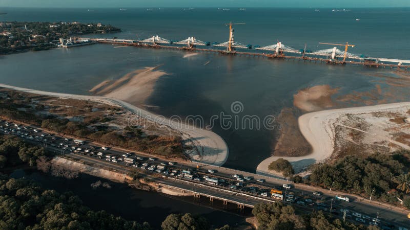 Aerial view of Tanzanite Bridge, Dar es salaam, Tanzania with forest trees by the sea and blue sky