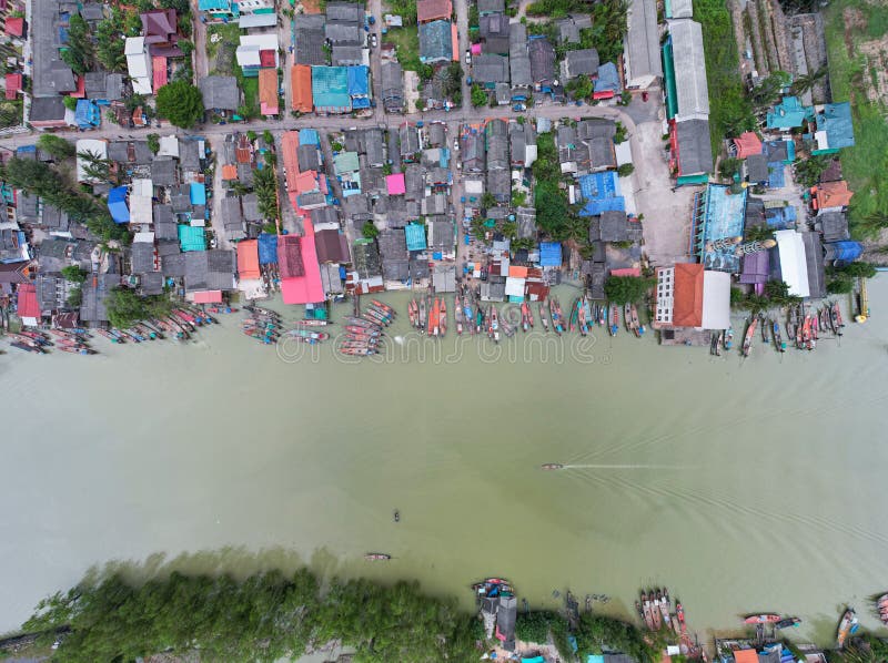 Aerial view top view of the fisherman village with fishing boats and house roof at the pier in suratthani Thailand. Panorama high