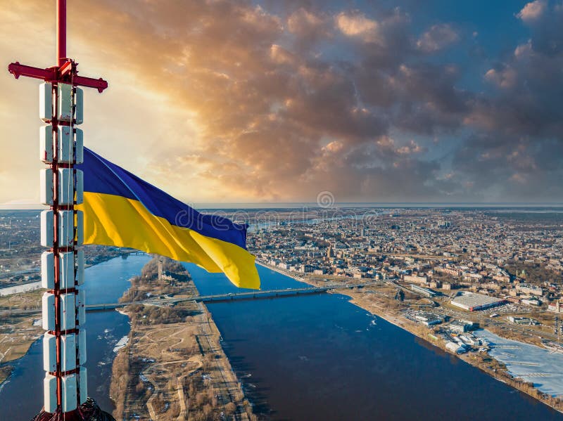Aerial view of the Ukrainian flag waving on top of the Riga TV Tower