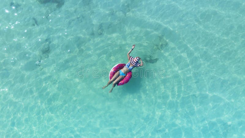 Aerial View with Woman in Bikini Sunbathing As Laying on Swim Ring As ...