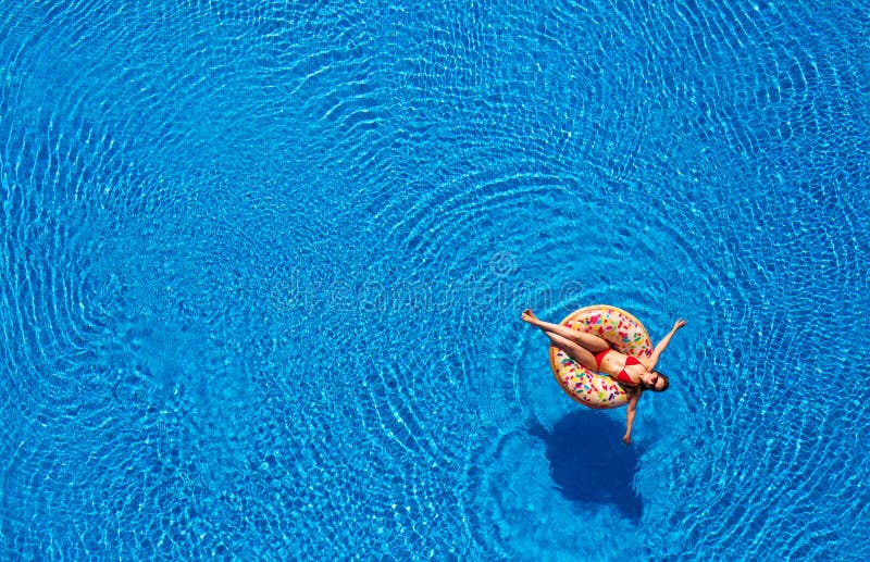 Aerial View of a Woman in Red Bikini Lying on a Donut in the Pool Stock ...