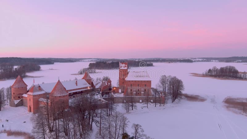 Aerial winter sunset view of Trakai Island Castle, frozen Galve lake, Lithuania.