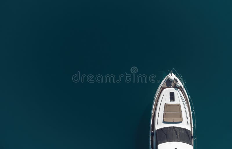 Aerial yacht on calm sea. Luxury cruise trip. View from above of white boat on deep blue water. Aerial view of rich